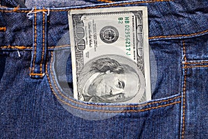 One hundred American dollars bill in pocket of blue jeans