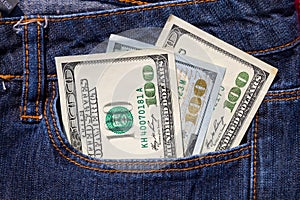 One hundred American dollars bills in pocket of blue jeans