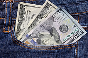 One hundred American dollars bills in pocket of blue jeans