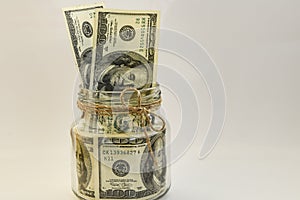 One hundred american dollars in the jar on the white backround with copy space, savings,
