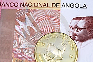 A one hundred Angolan kwanza bank note with a gold South African krugerrand coin