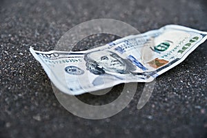 One hundred dollar banknote on ground. Lost money concept