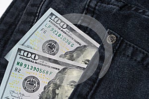 One hundred dollar banknote money in pocket jeans pants background texture. 100 dollar bill close up