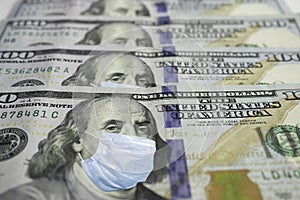 One Hundred Dollar Bill With Medical Face Mask on Benjamin Franklin. Coronavirus affects global stock market. World economy hit by