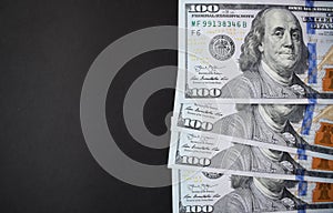 One hundred dollar bills on black background