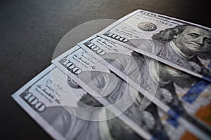 One hundred dollar bills on black background photo