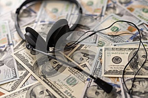 one hundred dollar bills and headphones. Close-up.