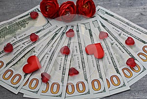 One hundred dollar bills, money for $100 fan lie with red hearts and red roses, risk and money, gift of money, February 14