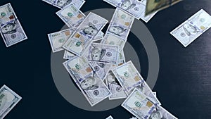 One hundred dollar money banknotes flying and falling on dark background.