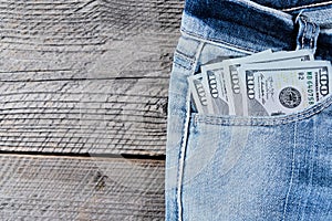 A one hundred dollar notes in the front pocket of denim trousers