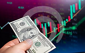 one hundred dollars banknote on the background of stock market graph