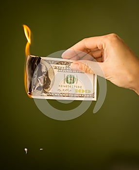 One hundred dollars burn with fire in their hands