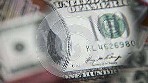 One Hundred Dollars Inspecting Under Magnifying Glass on Money Background