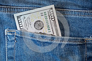 Pile of one hundred american dollar banknotes in the back jeans pocket. Close up one hundred US Dollar as symbol of poverty and