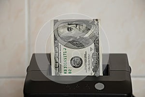 One hundred dollars lie in a receipt printer on a light background, money and income