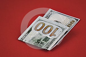one hundred dollars lying on red background close up