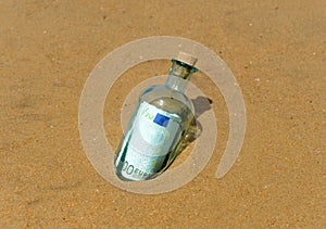 One hundred euros in a bottle on the sand of the beach