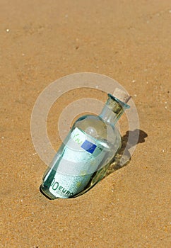 One hundred euros in a bottle on the sand of the beach