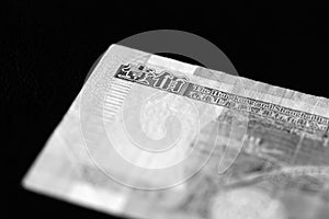 One hundred Hong Kong dollars banknote on a dark background. Black and white