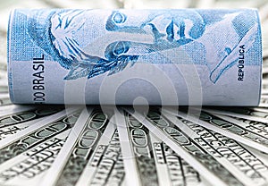 one hundred reais notes and one hundred dollar bills, concept of the Brazilian and United States economy, rising dollar photo