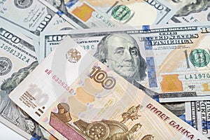 One hundred rubles lying on american dollars as a symbol of weakness russian national currency and strengthening of american