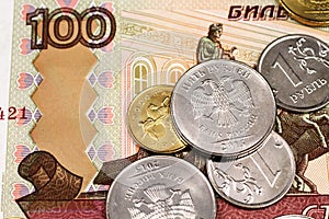 A one hundred Russian ruble bank note with an assortment of Russian coins