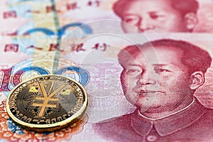 One hundred yuan banknotes, next to an e-RMB gold coin, digital version of the yuan. Concept of new digital currency of the photo