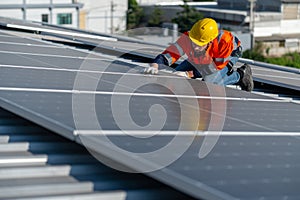 One of industrial technician worker touch to check and maintenance solar cell panels on rooftop of factory building. Green and
