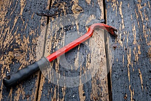 One iron nail and nail puller on a wooden background photo