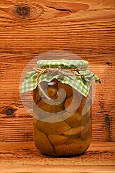 One jar of pear compote at brown vintage wood surface