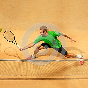 The one jumping player, caucasian fit man, playing tennis on the earthen court