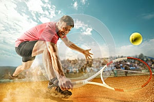 The one jumping player, caucasian fit man, playing tennis on the earthen court with spectators