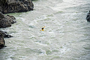 One kayaker on a yellow kayak floats on the mountain river Katun.