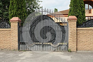 One large black metal gate with an iron wrought iron pattern