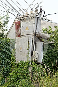 One large gray iron transformer with electrical wires