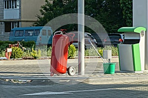One large metal canister of red fire extinguisher on wheels