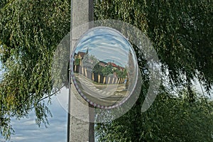 One large round observation mirror on a concrete pillar