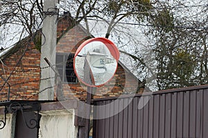 One large round observation mirror on a pillar above the fence