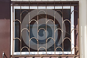 One large square window behind a brown iron grating