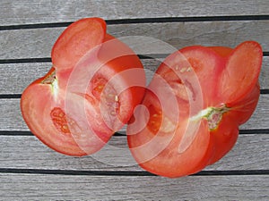 One large tomato on teak wood