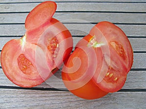 One large tomato on teak wood