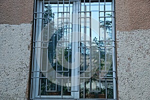 one large white window behind a gray iron grating