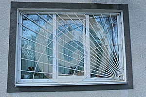 One large white window behind an iron grating