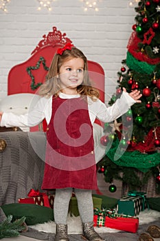 One little Caucasian cute girl smiling with present box in the festive New year studio room