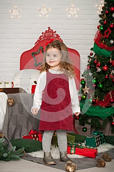 One little Caucasian cute girl smiling with present boxes in the festive New year studio room