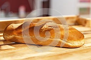 One loaf of bread on a wooden counter in a store. Close-up