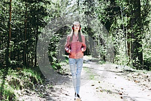 One lovely slim fit thin teen girl enjoying, listening to music in the forest while walking spring day forest or park