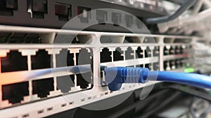 One male IT engineer working in a data center with rows of server racks and super computers.