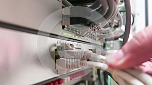 One male IT engineer working in a data center with rows of server racks and super computers.