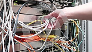 One male IT engineer working in a data center with rows of server racks and super computers.